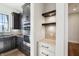 Kitchenette showcases stainless steel appliances, custom cabinetry, and floating shelves at 580 Exmoor Dr, Carmel, IN 46032