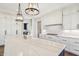 Kitchen island featuring marble countertops, undermount sink, and view of the gas range cooktop at 580 Exmoor Dr, Carmel, IN 46032
