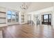 Spacious living room with large windows, sleek hardwood floors, a modern chandelier, and built-in shelves at 580 Exmoor Dr, Carmel, IN 46032