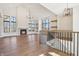 Spacious living room featuring a fireplace, sleek hardwood floors, large windows, a modern chandelier, and built-in shelves at 580 Exmoor Dr, Carmel, IN 46032