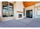 Cozy outdoor patio with fireplace, wood ceiling, black-framed windows and glass doors at 580 Exmoor Dr, Carmel, IN 46032