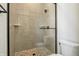 Modern glass shower with stone tile floor and grey stone patterned tile walls at 580 Exmoor Dr, Carmel, IN 46032