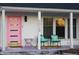 Charming front porch features a pink door and rocking chairs, offering a welcoming exterior at 6015 Pine Hill Dr, Indianapolis, IN 46235