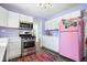 Bright kitchen featuring stainless steel appliances and a playful pink refrigerator at 6015 Pine Hill Dr, Indianapolis, IN 46235