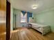 A bright bedroom with hardwood floors, a closet, and a single bed at 6346 Shelby St, Indianapolis, IN 46227