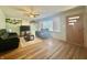 Cozy living area featuring hardwood flooring, a ceiling fan, and a large window with natural light at 6346 Shelby St, Indianapolis, IN 46227