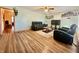 Spacious living room with gleaming hardwood floors, black sofas, and a ceiling fan at 6346 Shelby St, Indianapolis, IN 46227