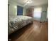 Bright primary bedroom with hardwood floors, large bed and vintage accents at 6346 Shelby St, Indianapolis, IN 46227