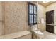 Elegant bathroom featuring stone walls, dark brown shuttered window, skylight and modern fixtures at 645 Ellsworth St, Indianapolis, IN 46202