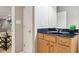 Bathroom featuring a wooden vanity, black countertop, and decorative mirror at 645 Ellsworth St, Indianapolis, IN 46202