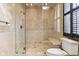 Walk-in shower featuring a travertine surround, bench, decorative inlay, and a glass enclosure at 645 Ellsworth St, Indianapolis, IN 46202