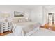 Bedroom with hardwood floors, natural light, neutral rug, white walls, art, and white painted dressers at 645 Ellsworth St, Indianapolis, IN 46202