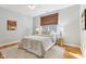 Comfortable bedroom featuring hardwood floors, a ceiling fan, and a queen bed with bedside lamps at 645 Ellsworth St, Indianapolis, IN 46202