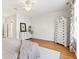 Open bedroom featuring hardwood floors, white walls, a ceiling fan, and white painted dressers at 645 Ellsworth St, Indianapolis, IN 46202