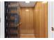Interior view of a residential elevator, featuring wood paneling and accordion gate at 645 Ellsworth St, Indianapolis, IN 46202