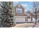 Charming two-story home featuring a white garage door, well-maintained lawn, and mature landscaping at 645 Ellsworth St, Indianapolis, IN 46202