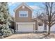 Charming two-story home featuring a white garage door, well-maintained lawn, and mature landscaping at 645 Ellsworth St, Indianapolis, IN 46202
