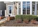 Inviting front door featuring glass and white trim, complemented by a large bay window and manicured landscaping at 645 Ellsworth St, Indianapolis, IN 46202