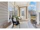 Inviting front porch with modern black chairs, pillows, plants, and a view of the neighborhood at 645 Ellsworth St, Indianapolis, IN 46202