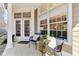 Welcoming front porch with black chairs, plants, decorative pillows, and large windows at 645 Ellsworth St, Indianapolis, IN 46202