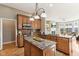 An open kitchen with wood cabinets, granite countertops, stainless steel appliances, and hardwood flooring at 645 Ellsworth St, Indianapolis, IN 46202