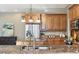 Kitchen with wood cabinets, granite countertop, stainless steel appliances, and a pendant light at 645 Ellsworth St, Indianapolis, IN 46202