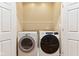 Bright laundry area features a Whirlpool washer and dryer, and white shelving for optimal organization and utility at 645 Ellsworth St, Indianapolis, IN 46202