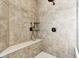 Well-lit shower featuring neutral tile, a shower bench, and modern shower head fixtures at 645 Ellsworth St, Indianapolis, IN 46202