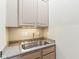 Utility sink with stainless steel basin, granite countertop, and light wood cabinets at 645 Ellsworth St, Indianapolis, IN 46202