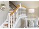 Elegant staircase with white railings and wood treads, complemented by a comfortable chair at 645 Ellsworth St, Indianapolis, IN 46202