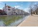 Picturesque waterfront featuring modern residential buildings, a serene canal, and tree-lined walkways at 645 Ellsworth St, Indianapolis, IN 46202