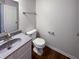 This bathroom has a toilet and a sink with gray counters and a white cabinet at 6454 Waterstone Dr, Indianapolis, IN 46268