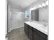 Modern bathroom featuring double sinks, a shower with glass doors, and neutral color palette at 6457 Flag Stop Dr, Whitestown, IN 46075
