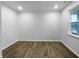A bright bedroom with light-colored walls, hardwood floors, and a large window offering natural light at 6457 Flag Stop Dr, Whitestown, IN 46075