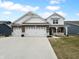 Charming home featuring a three-car garage, stylish brick accents, and inviting curb appeal at 6457 Flag Stop Dr, Whitestown, IN 46075