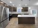 Modern kitchen with stainless steel appliances and center island, featuring dark wood cabinets and ample lighting at 6457 Flag Stop Dr, Whitestown, IN 46075