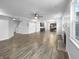 Bright living room showcasing hardwood floors, fireplace, and open floor plan leading to the kitchen at 6457 Flag Stop Dr, Whitestown, IN 46075