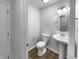 Simple half bathroom features a pedestal sink, a round mirror, and new flooring at 6457 Flag Stop Dr, Whitestown, IN 46075