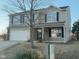 Charming two-story home featuring a two-car garage and a welcoming front porch at 7018 Allegan Dr, Indianapolis, IN 46217