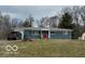 Charming one-story home with a gray facade, a red door, mature trees, and a well-manicured lawn at , Monrovia, IN 46157