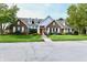 Charming brick home with a red front door, manicured lawn, and mature trees at 8221 Furlong Cir, Indianapolis, IN 46256