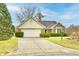 Charming brick home with a two-car garage and a well-manicured front lawn on a sunny day at 8221 Furlong Cir, Indianapolis, IN 46256