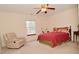 Bright bedroom features a ceiling fan, comfortable chair and a window overlooking the backyard at 10120 Youngwood Ln, Fishers, IN 46038