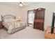 Cozy bedroom features a comfortable bed, wooden dresser and armoire, and a window at 10120 Youngwood Ln, Fishers, IN 46038
