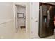 Hallway view showcasing a stainless steel refrigerator and utility closet at 10120 Youngwood Ln, Fishers, IN 46038
