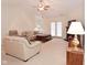 A cozy living room with carpet, a ceiling fan, comfortable seating, and a fireplace at 10120 Youngwood Ln, Fishers, IN 46038