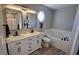 Well-lit bathroom featuring double sinks, a soaking tub, and modern fixtures at 10645 Aspen Dr, Fishers, IN 46037