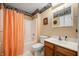 Compact bathroom with shower-tub combo, decorative wallpaper border, and peach shower curtain at 1114 Northfield Ln, Anderson, IN 46011