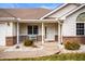 A detailed view of the front porch with brick accents and manicured landscaping at 1114 Northfield Ln, Anderson, IN 46011