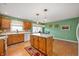 Kitchen features wood cabinetry, white appliances, and a central island for food preparation at 1114 Northfield Ln, Anderson, IN 46011